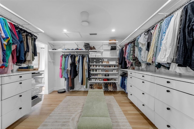 spacious closet featuring light wood-type flooring and attic access