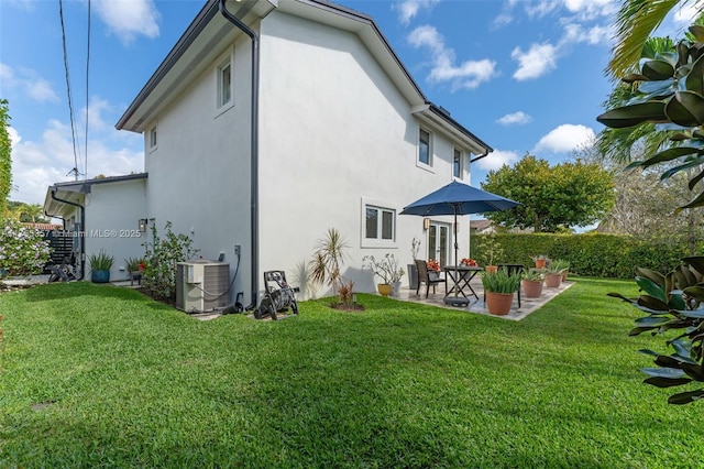 back of property featuring central AC, a patio, a lawn, and stucco siding