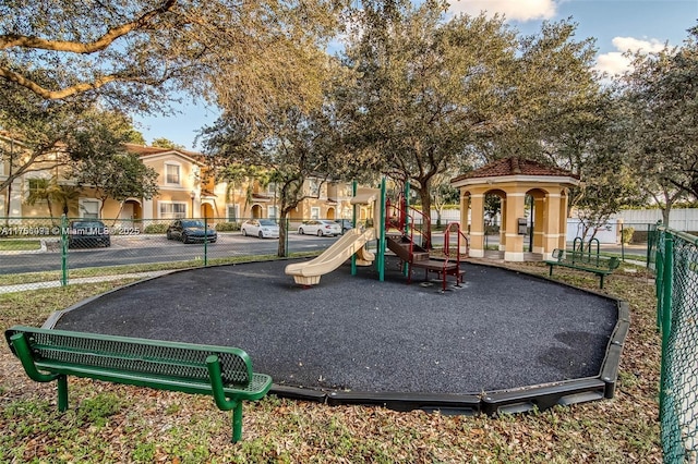 community playground featuring fence and a residential view