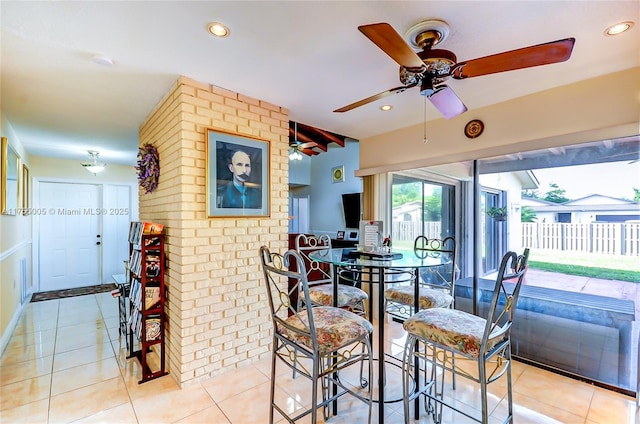 dining area with recessed lighting, light tile patterned flooring, and brick wall