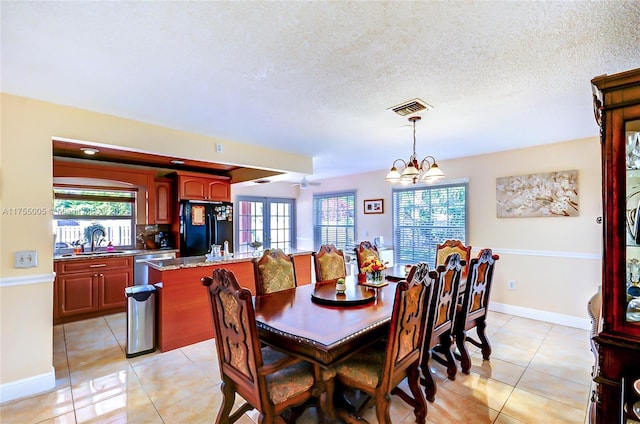 dining room with visible vents, light tile patterned flooring, a textured ceiling, baseboards, and ceiling fan with notable chandelier