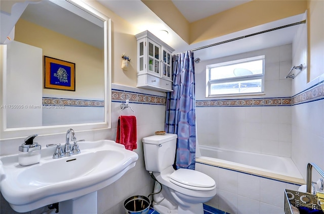 full bathroom with toilet, tiled shower / bath, tile walls, and a sink