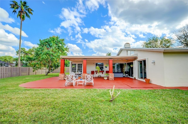 back of property featuring a yard, a patio area, fence, and stucco siding