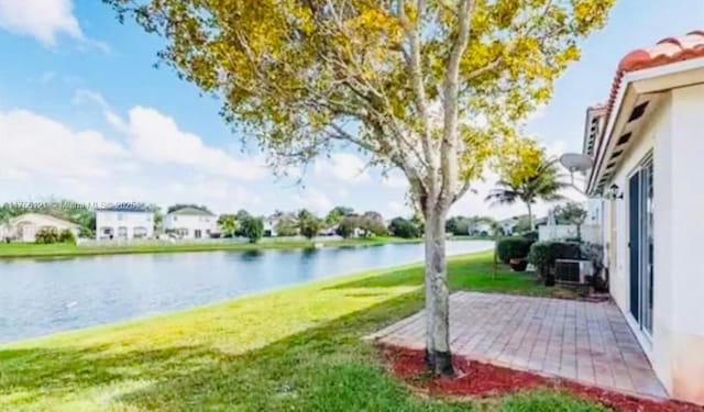 view of yard with a water view and a patio