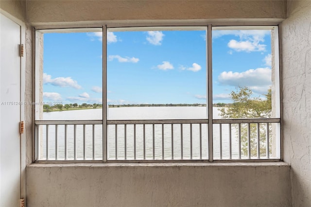 unfurnished sunroom featuring a water view