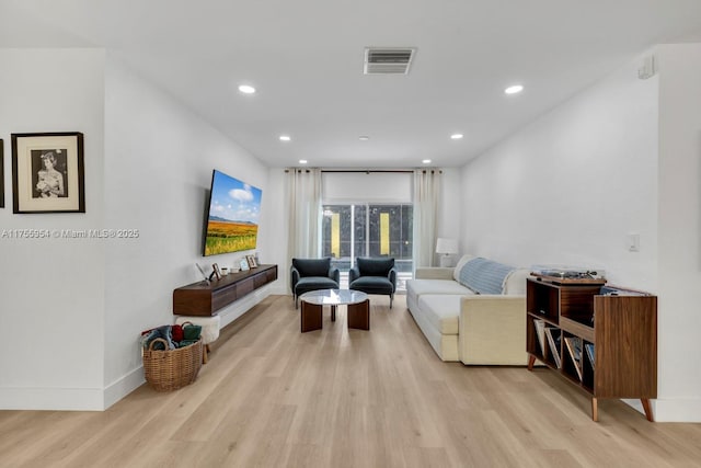 living area featuring light wood-style flooring, visible vents, baseboards, and recessed lighting