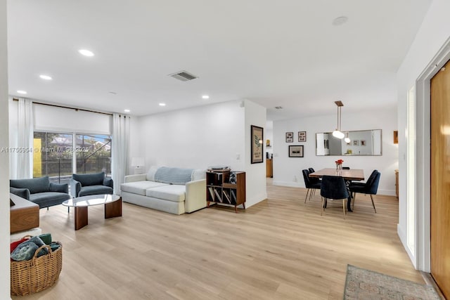 living area featuring baseboards, recessed lighting, visible vents, and light wood-style floors