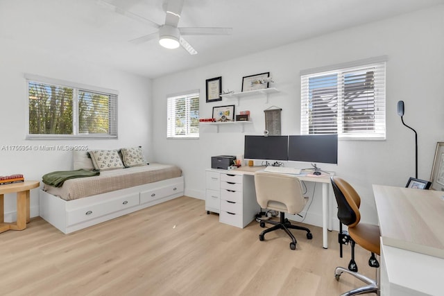 office area with a ceiling fan, light wood-type flooring, and baseboards