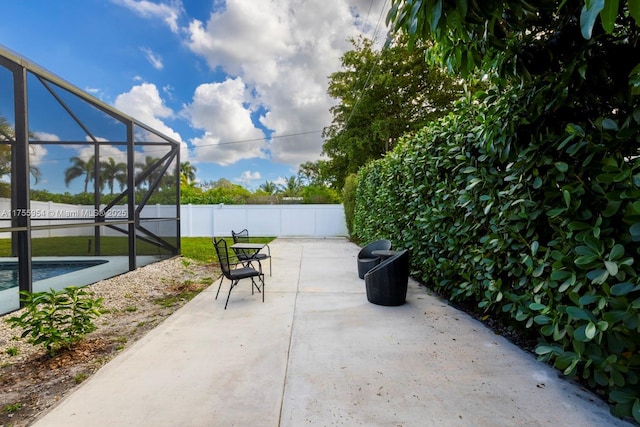 view of patio / terrace with a lanai, a fenced backyard, and a fenced in pool