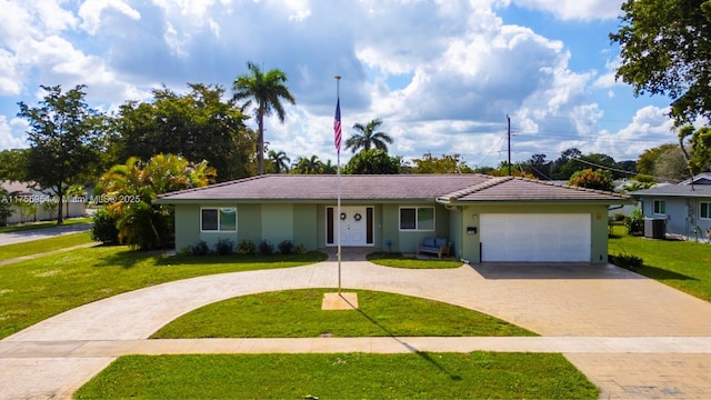 ranch-style home featuring an attached garage, a tile roof, decorative driveway, stucco siding, and a front lawn