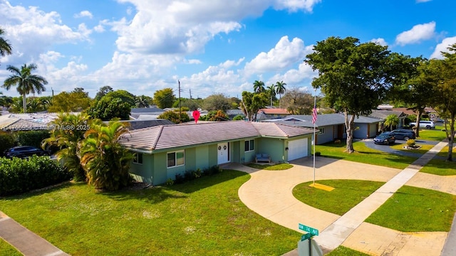 ranch-style home with an attached garage, a tiled roof, concrete driveway, and a front yard