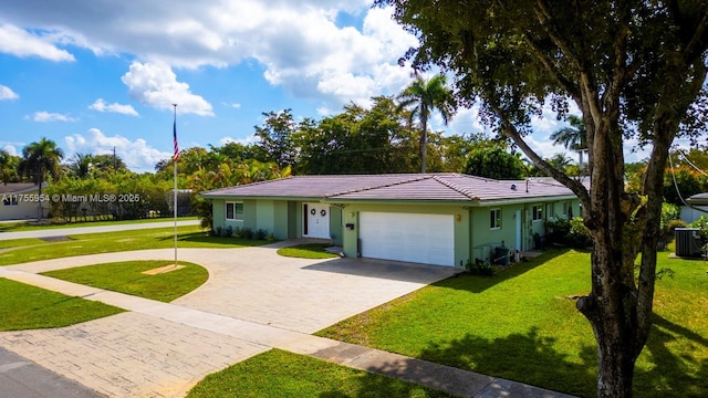 single story home featuring a garage, decorative driveway, a front yard, and stucco siding