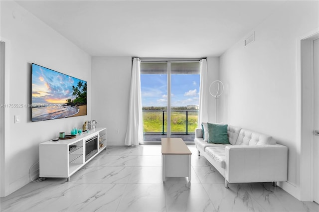 living area with marble finish floor, visible vents, and baseboards