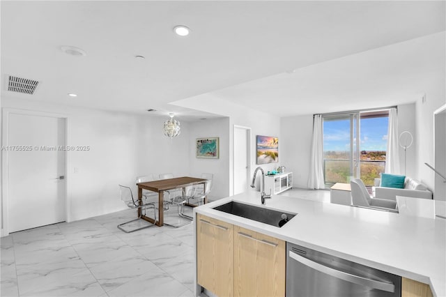 kitchen featuring modern cabinets, a sink, marble finish floor, light countertops, and stainless steel dishwasher