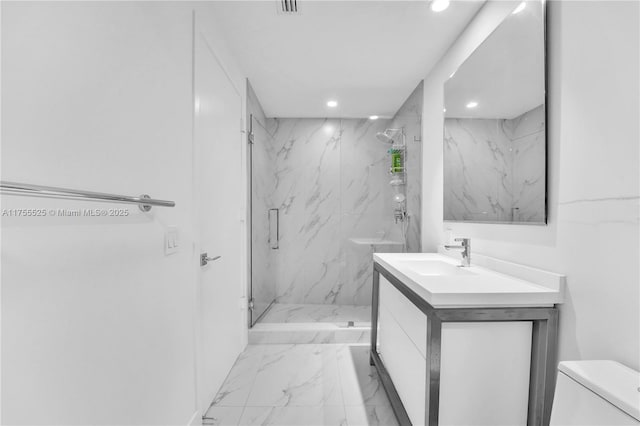 bathroom featuring marble finish floor, a marble finish shower, recessed lighting, toilet, and vanity