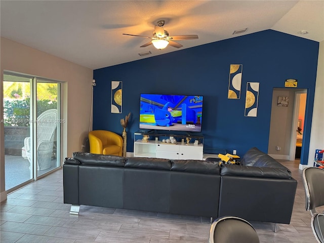 living room featuring wood tiled floor, visible vents, vaulted ceiling, and a ceiling fan