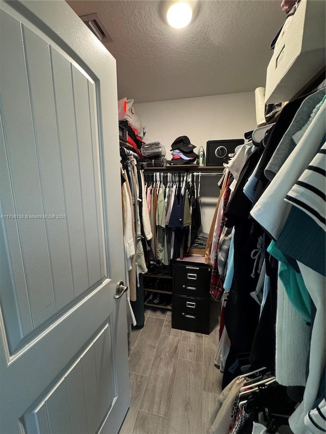 spacious closet with wood tiled floor and visible vents