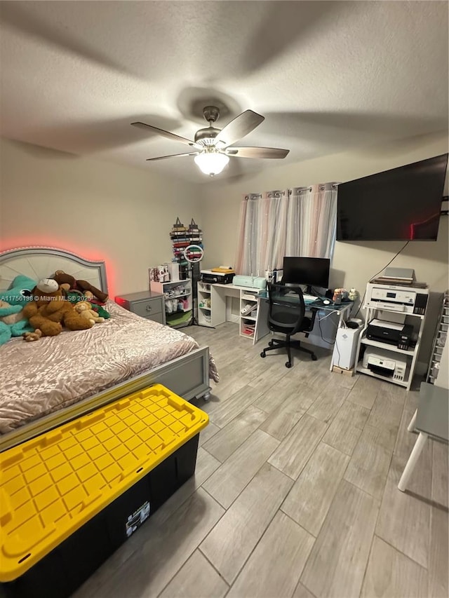 bedroom with wood tiled floor, ceiling fan, and a textured ceiling