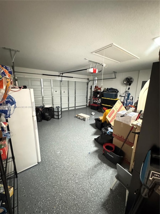 garage featuring a garage door opener and freestanding refrigerator