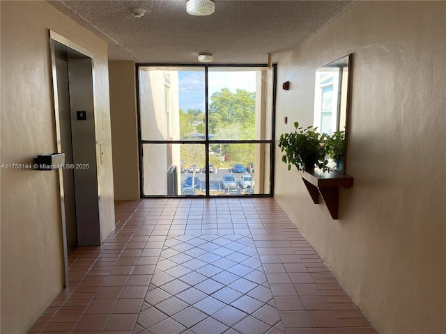 tiled empty room featuring floor to ceiling windows, a textured ceiling, and a textured wall