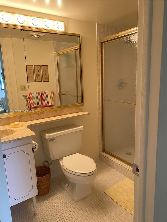 full bath featuring a stall shower, vanity, toilet, and tile patterned floors