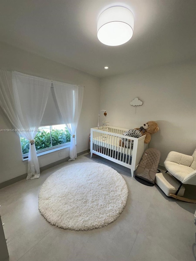 unfurnished bedroom featuring finished concrete flooring and baseboards