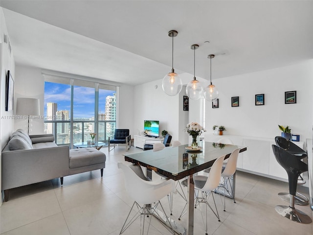 dining area featuring expansive windows and light tile patterned floors