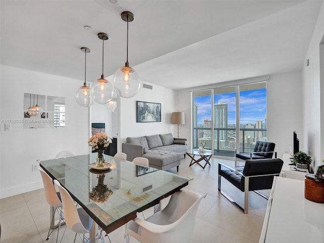 dining area with floor to ceiling windows, light tile patterned flooring, visible vents, and baseboards