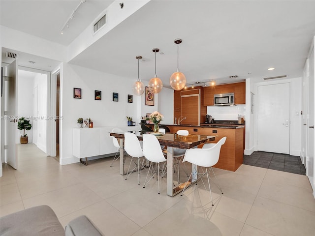 dining area with light tile patterned floors, rail lighting, and visible vents