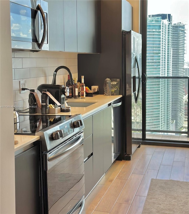 398 NE 5th St Unit 4005, Miami, FL 33132 - kitchen with stainless steel appliances, light countertops, tasteful backsplash, and light wood-style flooring
