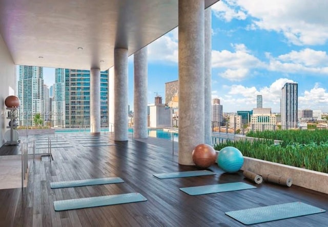 398 NE 5th St Unit 4005, Miami, FL 33132 - workout area with a view of skyline, wood finished floors, and decorative columns