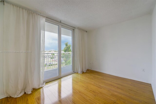 bedroom with a textured ceiling and wood finished floors