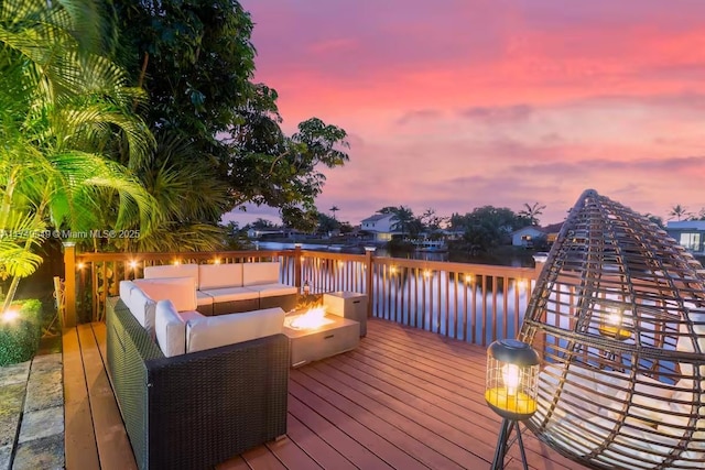 deck featuring a water view and an outdoor living space with a fire pit