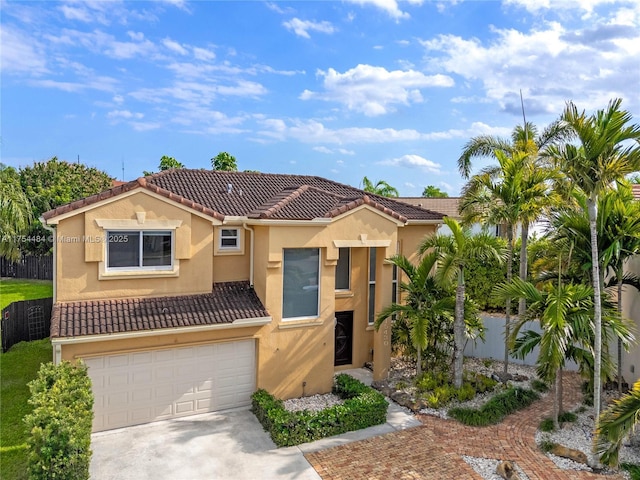 view of front of property featuring a garage, fence, a tiled roof, concrete driveway, and stucco siding