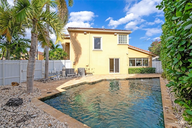 rear view of house with a patio area, fence, central AC, and stucco siding