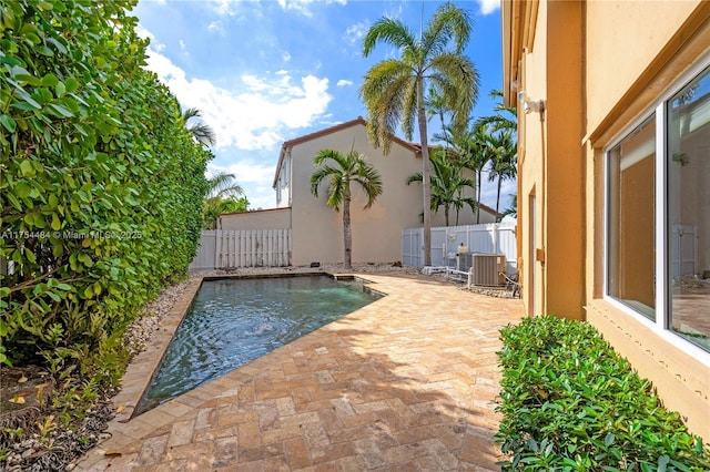 view of swimming pool featuring a patio area, a fenced backyard, and central air condition unit