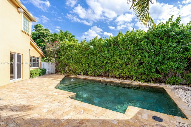 outdoor pool with a patio and a fenced backyard