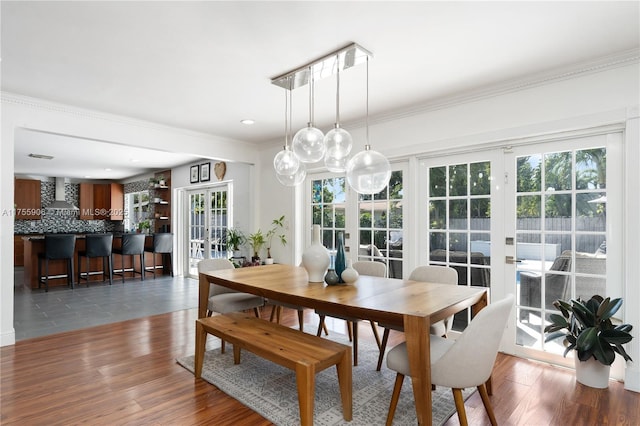 dining area featuring french doors, wood finished floors, and crown molding