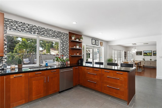 kitchen featuring brown cabinetry, a wealth of natural light, dishwasher, and a sink