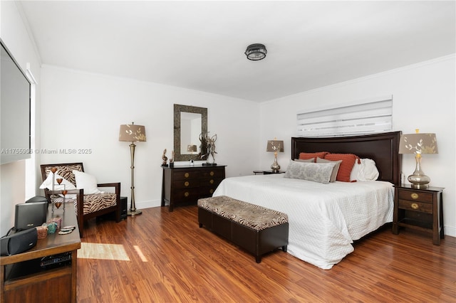 bedroom featuring crown molding, baseboards, and wood finished floors