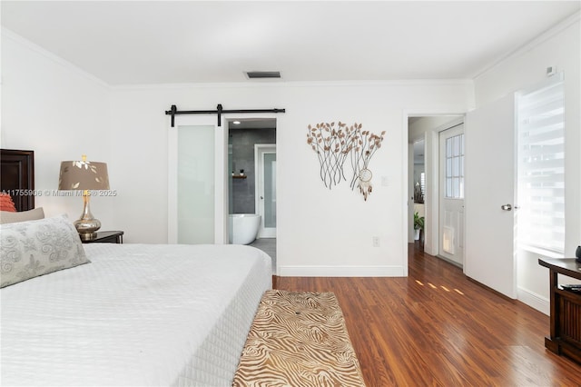 bedroom featuring a barn door, baseboards, visible vents, wood finished floors, and crown molding