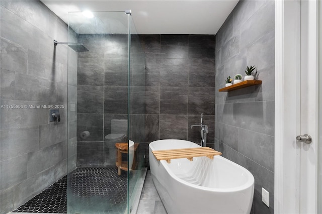 full bath featuring tile walls, a freestanding bath, and a shower stall