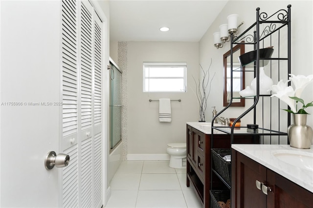 full bath featuring baseboards, toilet, tile patterned floors, vanity, and a closet