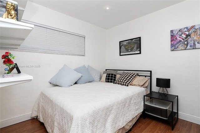 bedroom with baseboards and wood finished floors