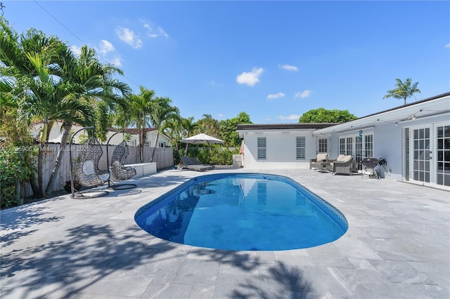 view of pool with french doors, a patio area, a fenced backyard, and a fenced in pool