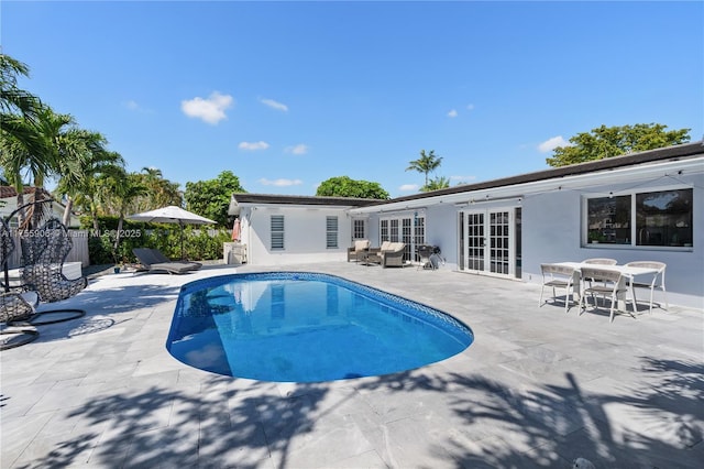 view of swimming pool with a fenced in pool, french doors, a patio area, fence, and an outdoor structure