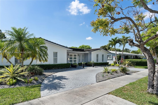 view of front of property with decorative driveway and stucco siding