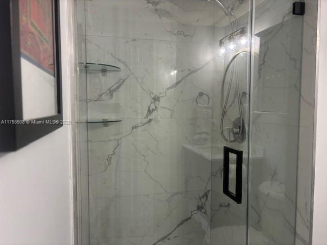 bathroom featuring a marble finish shower