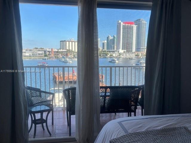 bedroom featuring a view of city and a water view