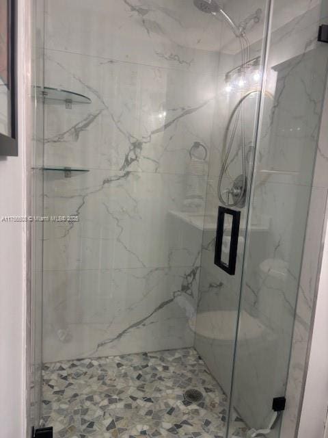 bathroom with a marble finish shower